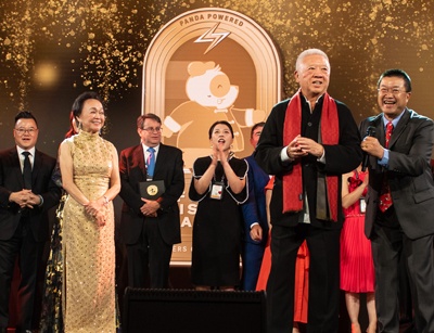 Andrew and Peggy Cherng Celebrating on Stage with Team