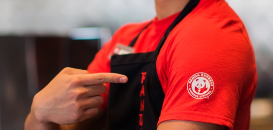 Panda Express Associate Pointing at Logo on Shirt